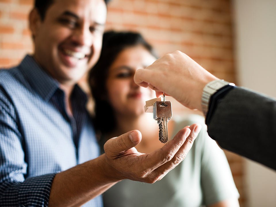 Cheerful couple with keys to their new home