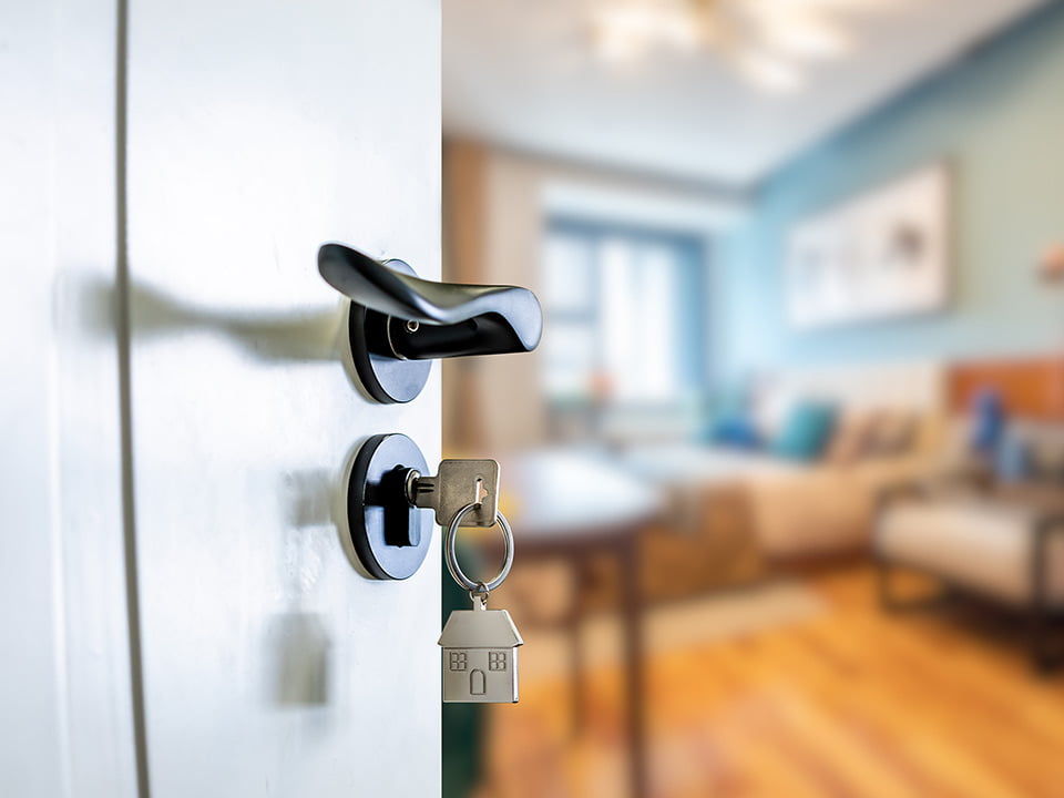 Open door with keys, key in keyhole