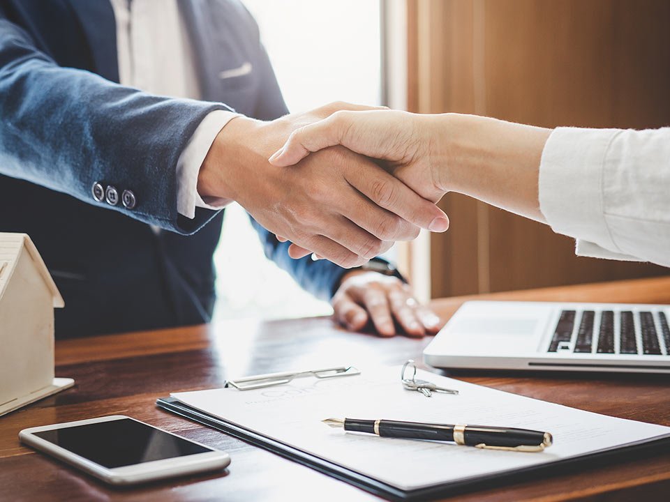 Estate agent and customer shaking hands after finished contract